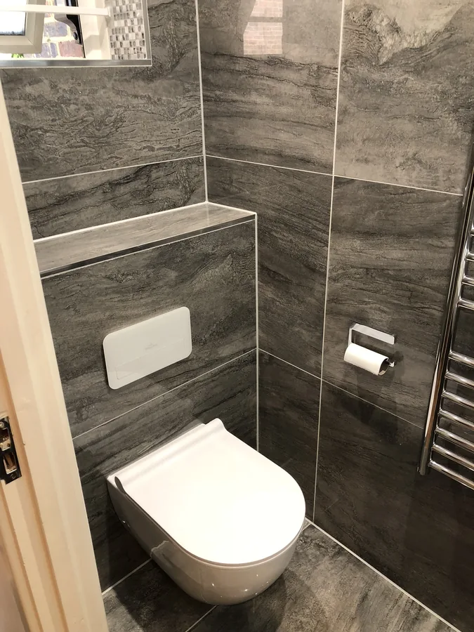 Wall-hung WC against dark stone-effect tiling
