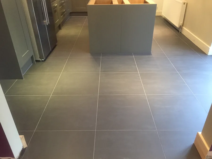 Large-format grey floor tiling around a kitchen island