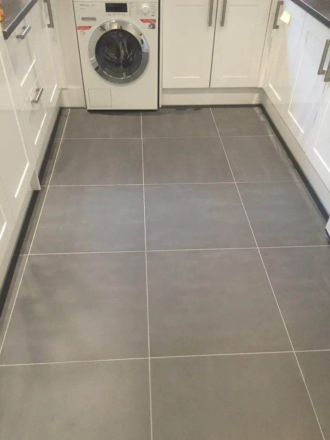 Large-format grey floor tiling in a kitchen and utility