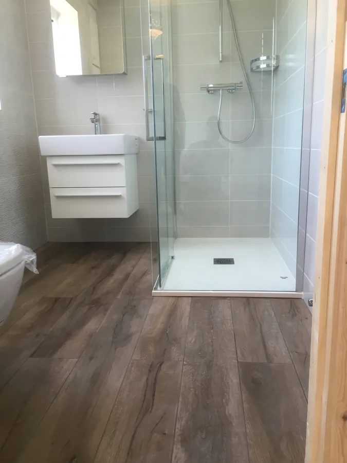 Shower enclosure with wood-effect floor tiling and vanity