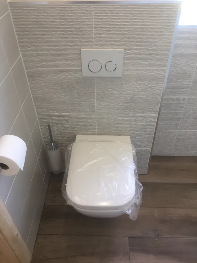 Wall-hung WC with textured wall tiling
