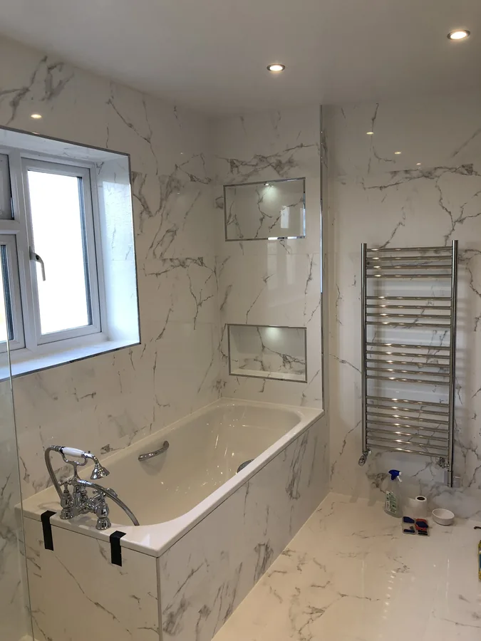Bath with marble-effect tiling and recessed storage niches