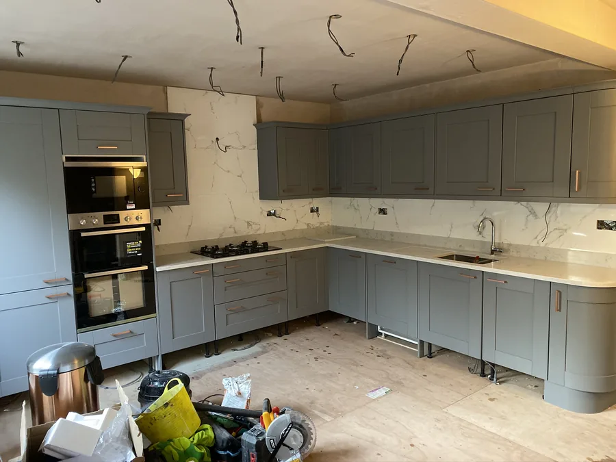 Marble-effect splashback fitted, kitchen mid-installation