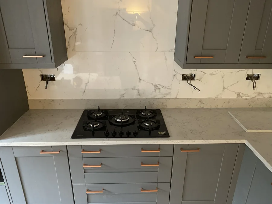 Marble-effect splashback behind a gas hob