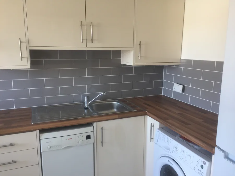 Grey metro-tile splashback behind a kitchen sink