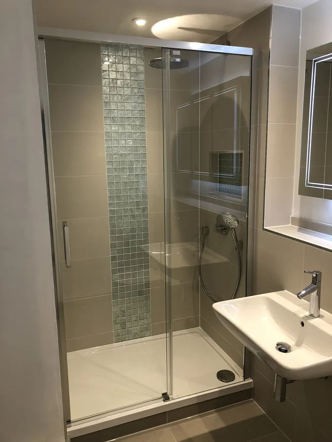 Shower enclosure with a mosaic feature strip beside the basin