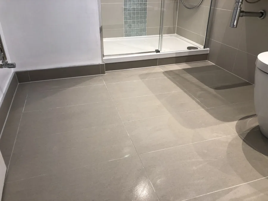 Large-format floor tiling leading into a shower enclosure
