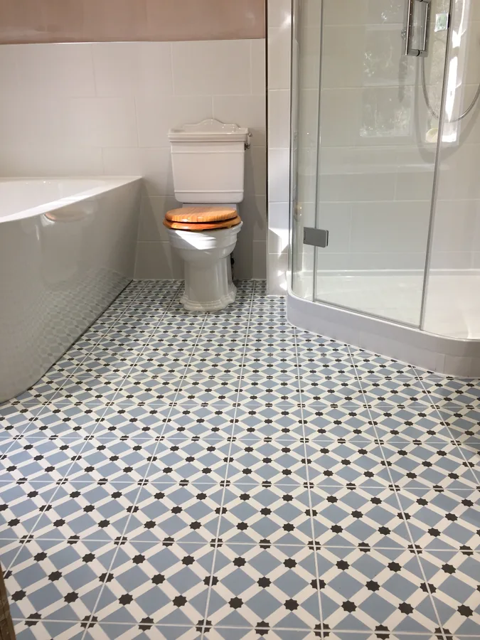 Geometric patterned floor tiling running to a shower enclosure